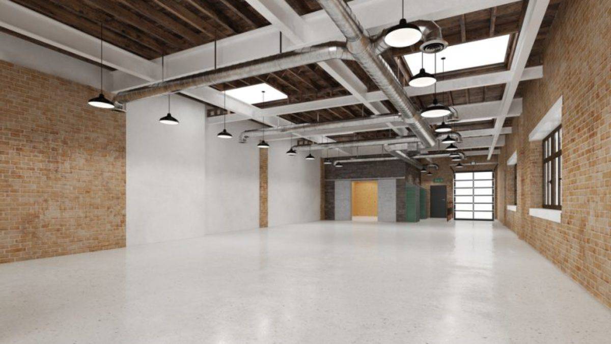 Amplio espacio en propiedad comercial con paredes de ladrillo, techos altos y gran iluminación natural para negocios o oficinas modernas.