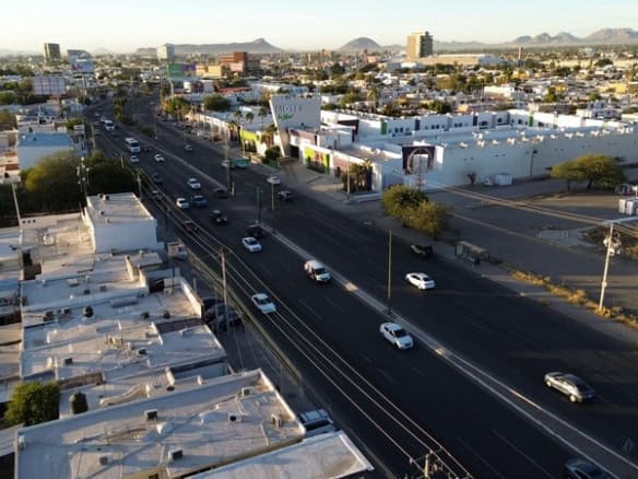 Calle principal en zona de bienes raíces comerciales en México con propiedades para inversión y alquiler.