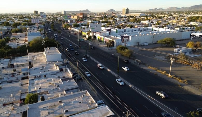Calle principal en zona de bienes raíces comerciales en México con propiedades para inversión y alquiler.