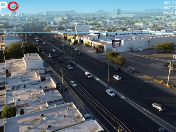 Fachada de propiedades comerciales en una zona urbana con amplias avenidas y movimiento vehicular, ideal para inversión en bienes raíces comerciales en México alt="Fachada de propiedades comerciales en una zona urbana con avenidas principales y tráfico vehicular" caption="Venta y alquiler de bienes raíces comerciales en ubicaciones estratégicas, con gran afluencia y accesibilidad en México." image_description="Imagen de una zona urbana con variadas propiedades comerciales, avenidas principales y tráfico vehicular, representando oportunidades de inversión en bienes raíces comerciales en México." relevance="Sí".