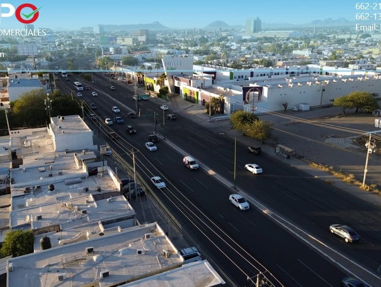 Fachada de propiedades comerciales en una zona urbana con amplias avenidas y movimiento vehicular, ideal para inversión en bienes raíces comerciales en México alt="Fachada de propiedades comerciales en una zona urbana con avenidas principales y tráfico vehicular" caption="Venta y alquiler de bienes raíces comerciales en ubicaciones estratégicas, con gran afluencia y accesibilidad en México." image_description="Imagen de una zona urbana con variadas propiedades comerciales, avenidas principales y tráfico vehicular, representando oportunidades de inversión en bienes raíces comerciales en México." relevance="Sí".