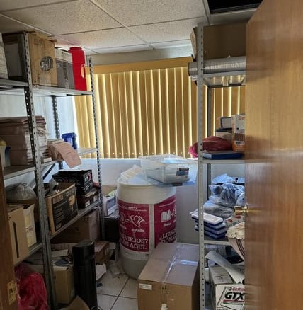 Sótano desordenado en oficina de bienes raíces comerciales con estantes llenos de materiales y enredos, ideal para encontrar oportunidades en inmuebles comerciales en venta o alquiler.