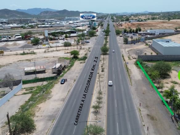 Carretera comercial en Querétaro con potencial de inversión, vista aérea con señalización de terreno disponible, ideal para bienes raíces comerciales y proyectos empresariales en zona estratégica.