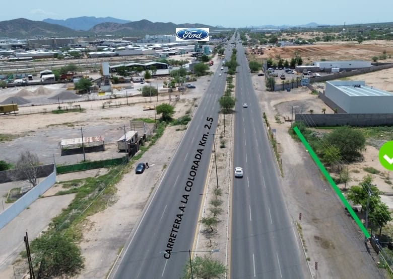 Carretera comercial en Querétaro con potencial de inversión, vista aérea con señalización de terreno disponible, ideal para bienes raíces comerciales y proyectos empresariales en zona estratégica.
