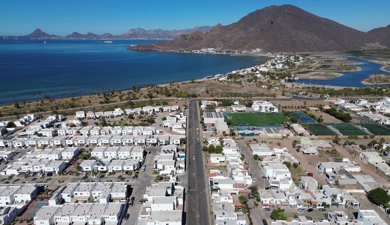 Alt text: Vista aérea de bienes raíces comerciales en Fompo con viviendas, áreas verdes y accesos cerca del lago y montañas en la región de Fompo.