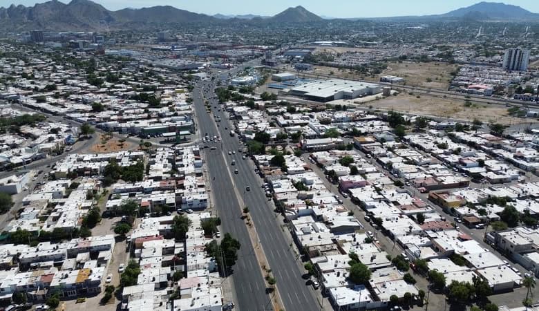 Amplia vista aérea de bienes raíces comerciales en clima urbano, mostrando desarrollos y parcelas en crecimiento en una zona con infraestructura moderna.