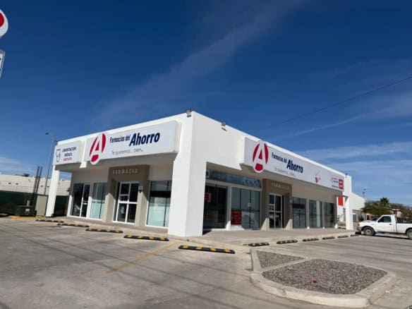 Farmacias del Ahorro en zona comercial, edificio moderno, ideal para inversión en bienes raíces comerciales, con amplias áreas de estacionamiento y acceso fácil.
