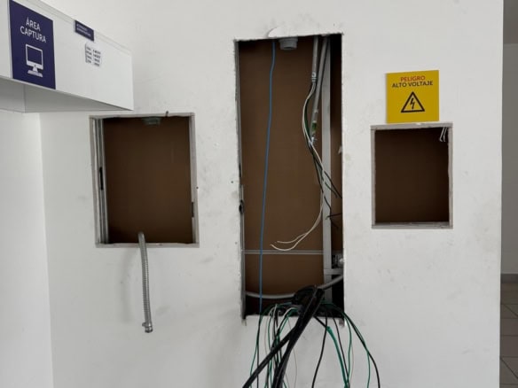 Cableado y conexiones eléctricas en obra, delimitadas para proyecto de bienes raíces comerciales, en proceso de instalación en un local.
