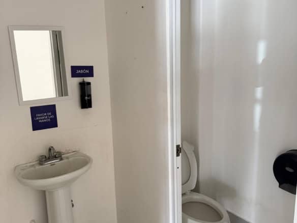 Acceso a baño con lavabo y sanitario, ideal para espacios comerciales y oficinas, equipado en inmueble de bienes raíces comerciales de Fompo.
