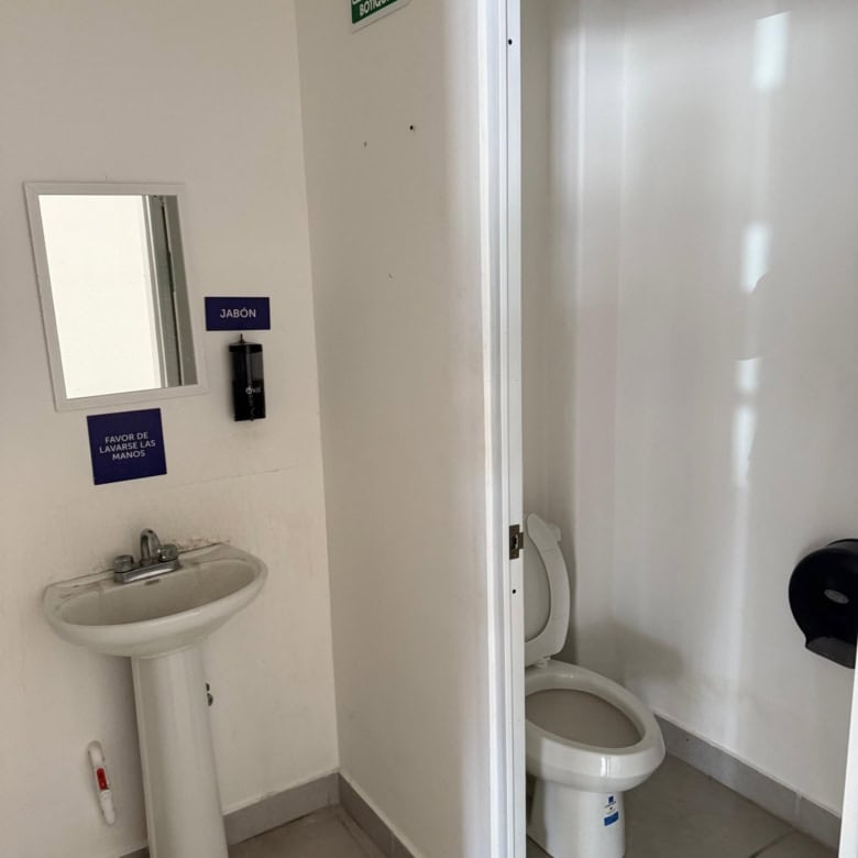 Acceso a baño con lavabo y sanitario, ideal para espacios comerciales y oficinas, equipado en inmueble de bienes raíces comerciales de Fompo.
