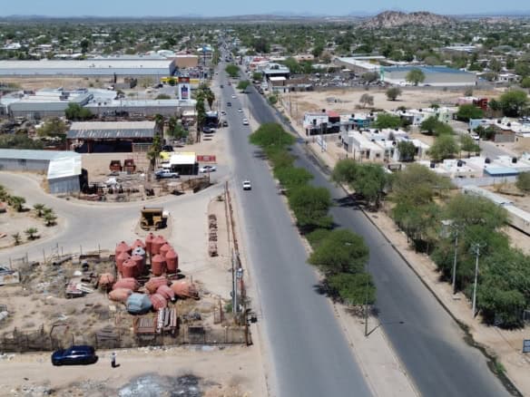 Amplia vista aérea de propiedades comerciales y terrenos para inversión en bienes raíces en una zona en desarrollo, con infraestructura y oportunidad de crecimiento en el mercado inmobiliario.