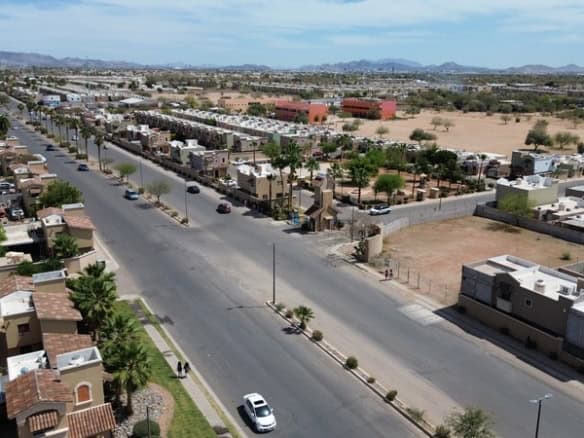 Estructura de imagen de bienes raíces comerciales en una zona urbana con casas y calles amplias en Fompo, mostrando una vista de la ciudad y áreas residenciales.