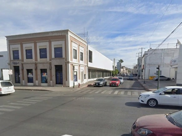 Modern edificio comercial en una esquina de calle principal en una zona urbana, ideal para oficinas o locales comerciales, con buen acceso y visibilidad.