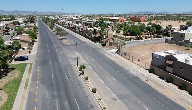 Imagen de una calle comercial en una zona urbana con propiedades en venta, mostrando un amplio espacio para negocios y desarrollo inmobiliario en una ciudad moderna.