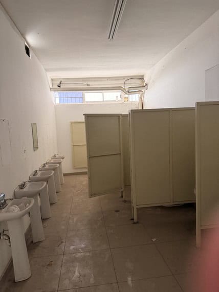 Baños públicos con urinarios y separadores, ideal para locales comerciales o espacios de alta afluencia en bienes raíces comerciales. Diseño funcional y limpio.