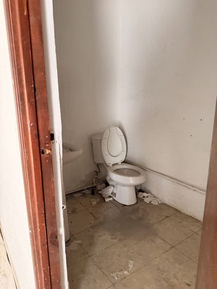 Sucia taza de baño en un espacio de oficina o local comercial con evidente deterioro y falta de mantenimiento.