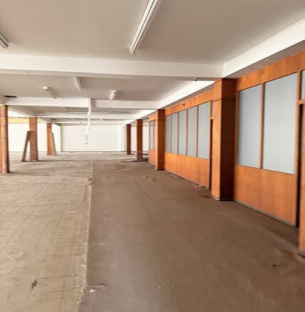 Amplio espacio de oficina en alquiler con paredes de madera y divisores de vidrio, ideal para negocios que buscan una oficina comercial moderna y funcional.