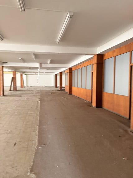 Amplio espacio de oficina en alquiler con paredes de madera y divisores de vidrio, ideal para negocios que buscan una oficina comercial moderna y funcional.