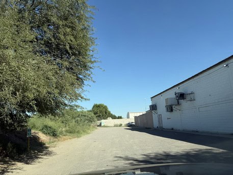 Fachada de edificio comercial en ubicación estratégica con amplio espacio de estacionamiento, ideal para negocios y oficinas en una zona de alta afluencia.
