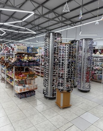 Letrinas, exhibidores y estantes en supermercados con variedad de productos y atención al cliente en un entorno comercial moderno.