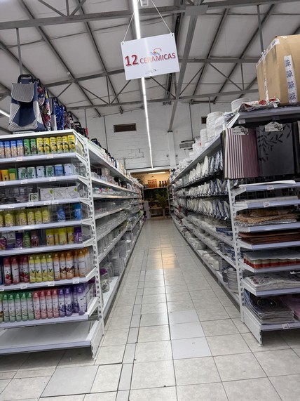 Amplia vista de estanterías con productos de oficina y artículos para el hogar en un comercio bien ubicado y accesible.